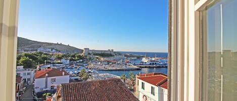 A coastal town with a historic fort, boats, and traditional buildings.