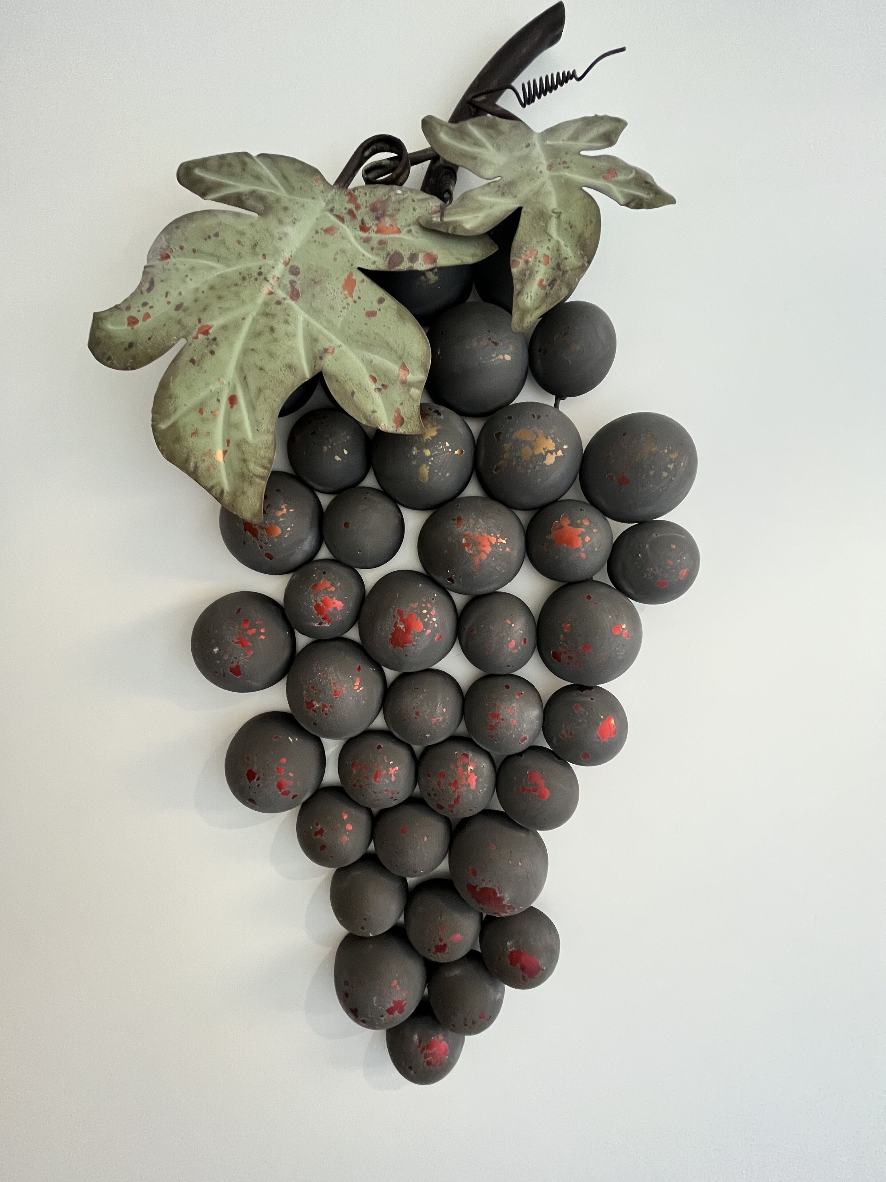 A decorative grapevine with leaves and grapes against a white background.