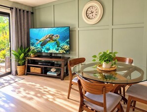 Un salon avec un téléviseur, des meubles en bois et une table en verre.