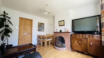 TV connectée, cheminée, livres, chaîne hi-fi