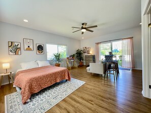 Relax in this serene bedroom with a large bed, desk, and seating area.