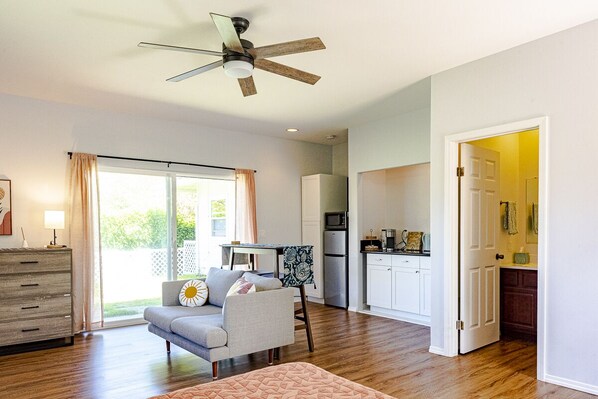 Relax in a spacious living area with a sofa, throw blanket, and sliding glass door leading to an outdoor space.