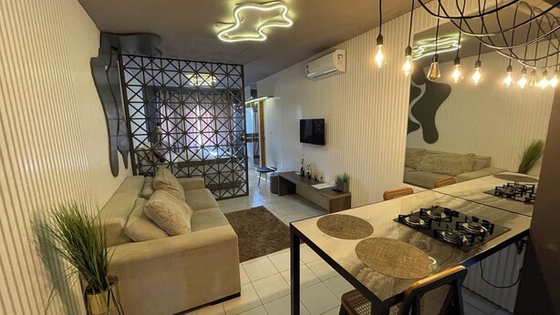 A modern living space with a sofa, dining table, and kitchen area.