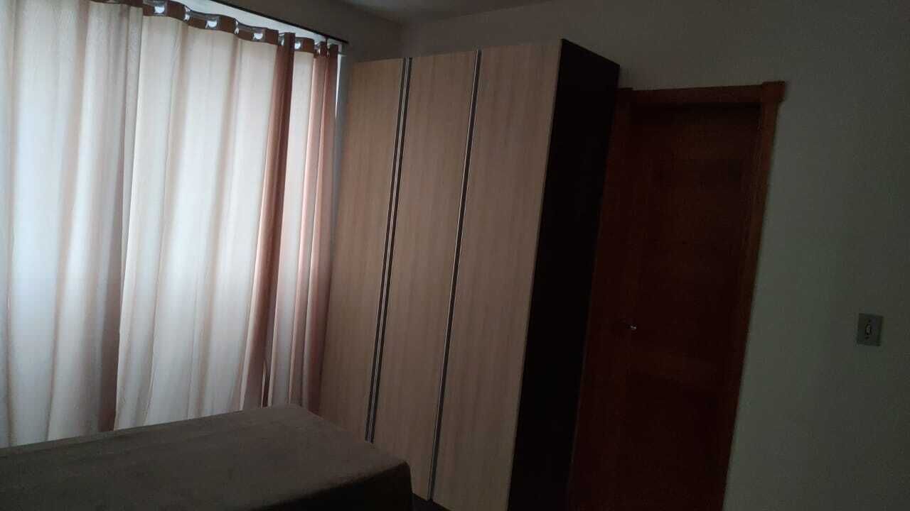 Une pièce comprenant un lit, une armoire, une porte et des rideaux.
