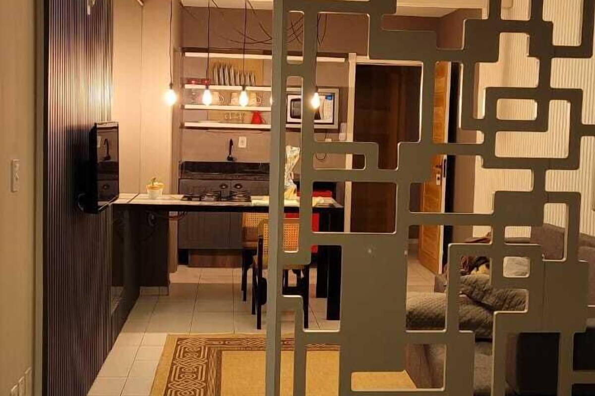 Un salon moderne avec un canapé, une table basse et un élément de séparation décoratif.