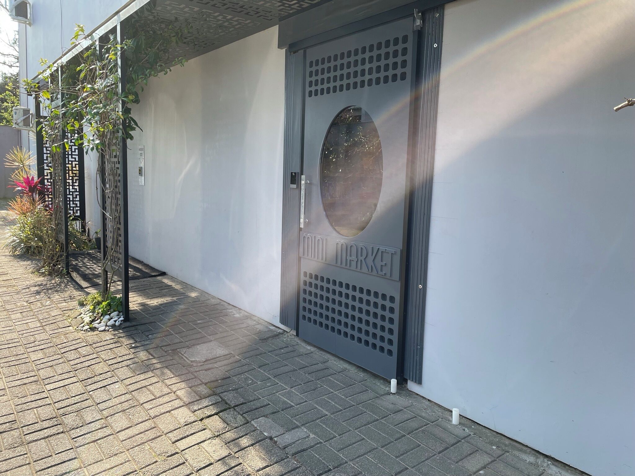 Um edifício moderno com uma porta cinzenta identificada como 