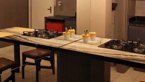 A modern kitchen with a central island, overhead lighting, and a microwave above the island.
