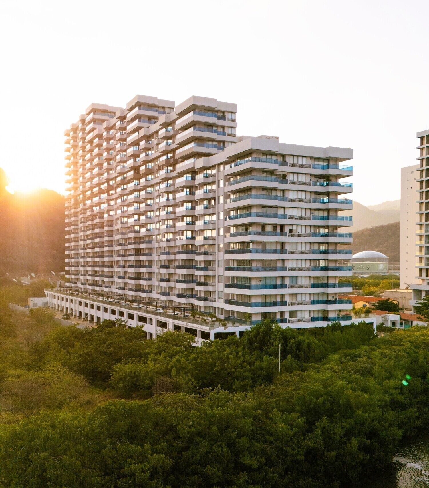 Edifício residencial com várias andares, varandas e um terraço no telhado.