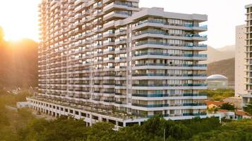 Edifício residencial com várias andares, varandas e um terraço no telhado.
