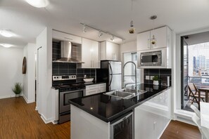 Enjoy cooking in this well-equipped kitchen with a large island, stove, refrigerator, and microwave.