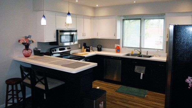 Una cocina moderna con una isla central, electrodomésticos de acero inoxidable y un ventanal que proporciona luz natural.
