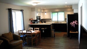 Una cocina moderna con comedor, muebles de madera y un refrigerador.