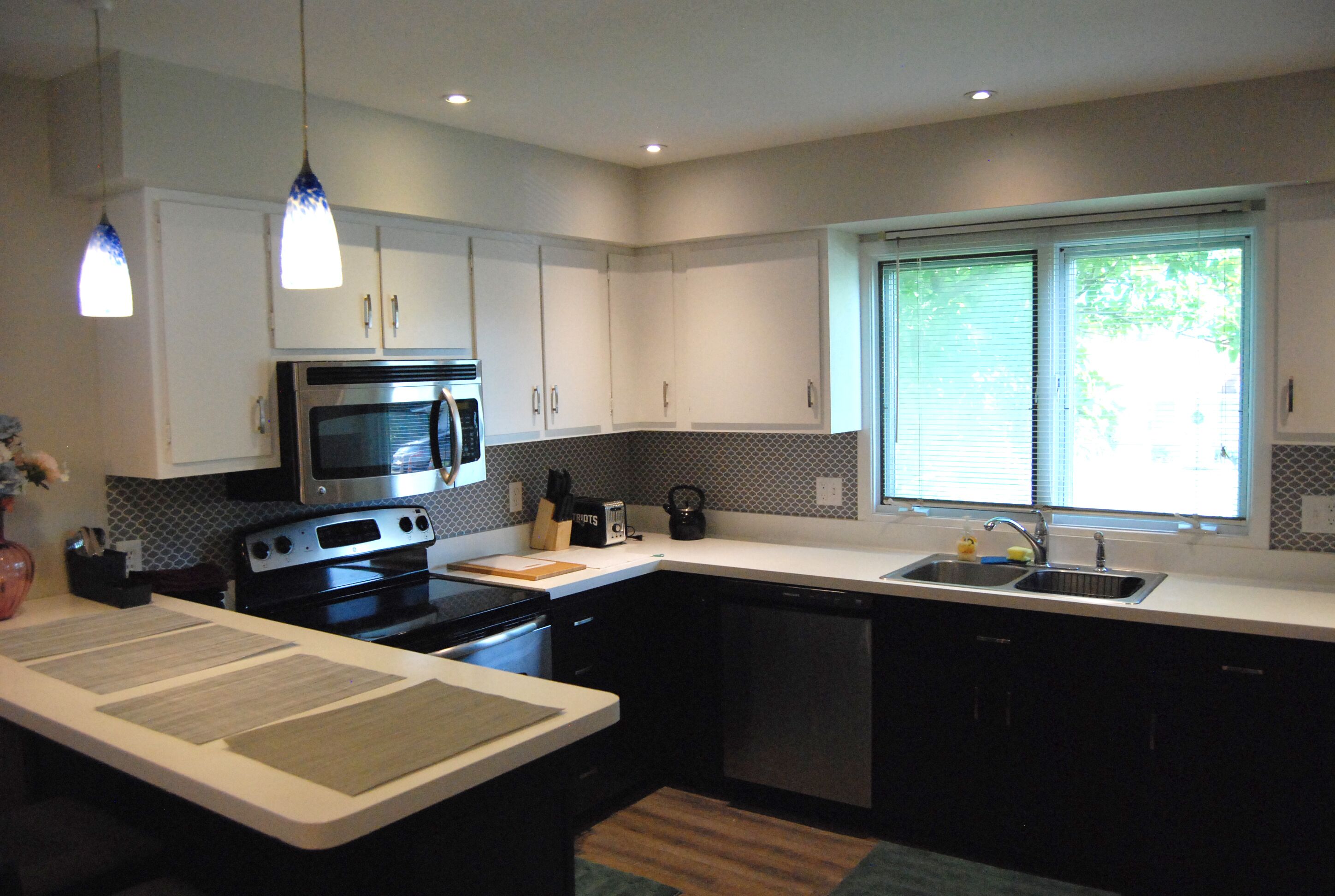 A modern kitchen with a microwave, stove, and sink.
