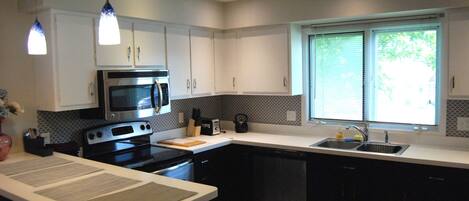 A modern kitchen with a microwave, stove, and sink.
