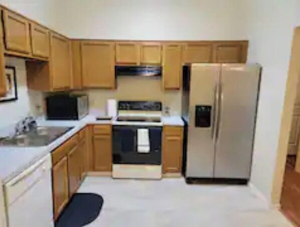 Enjoy cooking in this fully equipped kitchen with a refrigerator, microwave, oven, and sink.