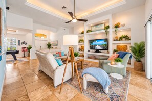 A modern living room with a sofa, armchair, and a small table with a lamp.