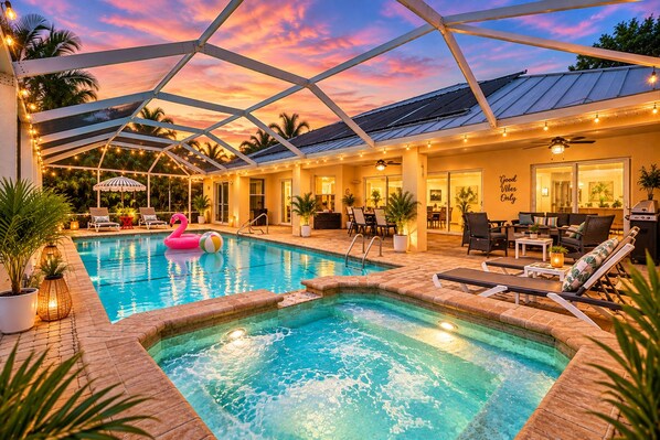 A pool area with a hot tub, lounge chairs, and a ceiling structure.