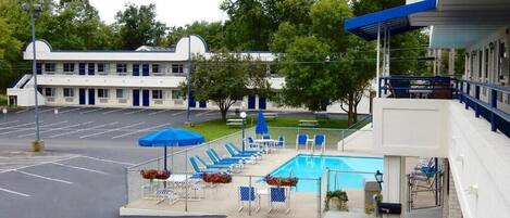 Ein Motel mit Schwimmbad, Außenbereich und Parkplatz.