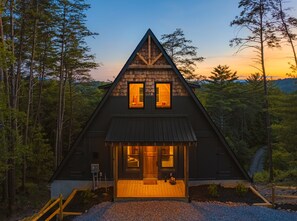 A cabin with a triangular roof, a front porch, and a small dog on the steps. - Hemptown Hollow! Creekfront:10 min from Blue Ridge (Mineral Bluff)