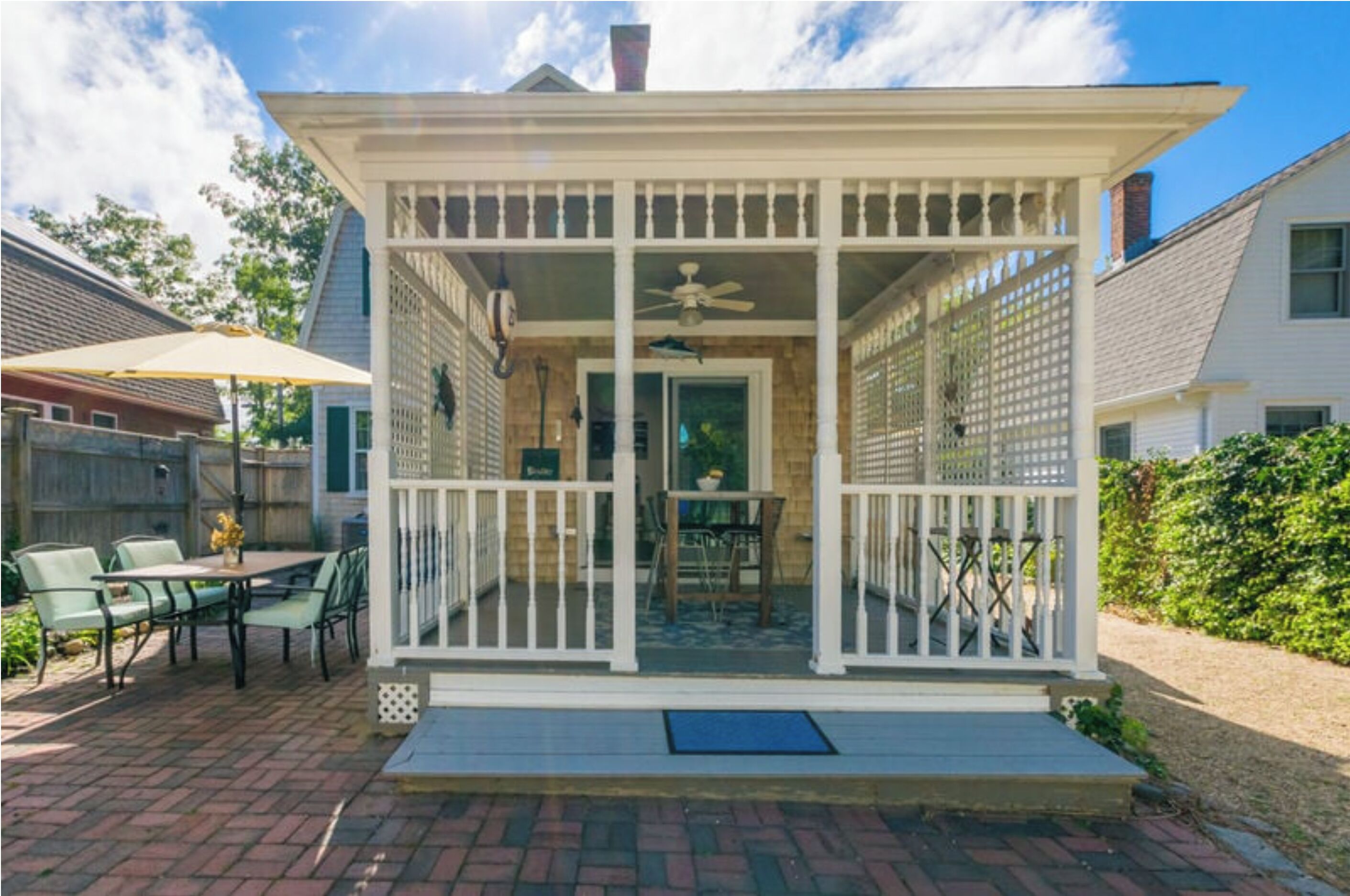 A covered patio with a table and chairs, a ceiling fan, and a view of the backyard.