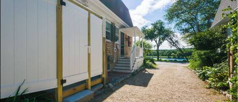 Un espace extérieur abrité avec un chemin de gravier menant à une terrasse en bois.