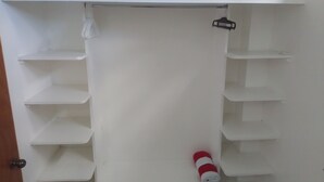 A white closet with multiple shelves and a hanging rod.