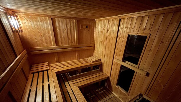 A sauna with wooden benches and a sloped ceiling. - Charming 1-bed for 4 pers with Sauna, WiFi, and Private Parking (Valloire)