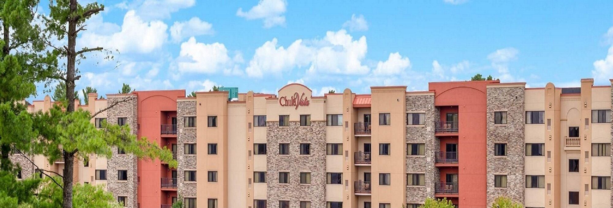 A multi-story hotel with a stone facade and balconies.