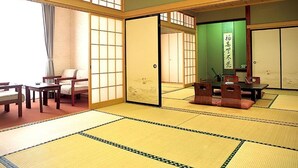 A traditional Japanese room with tatami flooring, sliding doors, and a low table with cushions. - yuzawahotel (Yuzawa)