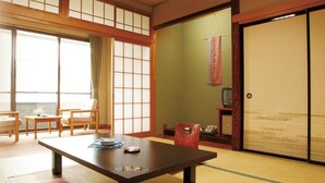 A traditional Japanese room with tatami flooring, a low table, and sliding doors. - yuzawahotel (Yuzawa)