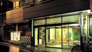 A modern building with a glass storefront and outdoor seating area. - yuzawahotel (Yuzawa)
