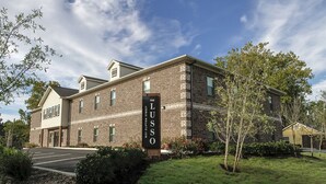 A brick building with a sign reading "The ILLUSO" on the front. - Luxury Furnished Rental in Conway, AR Unit 206 (Conway)