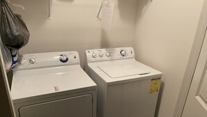 A laundry room with two stacked front-loading washing machines and a dryer. - Stylish Duplex with an Equine View (Indian Trail)