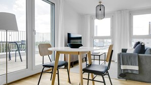 A modern living room with a round table, two chairs, a TV, and a sofa. - Sunlit Landstraße 1BR w/ Elevator & Playglound, Calm Area, by Blueground (Vienna)