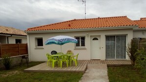 A house with a patio, a table with chairs, and a door. - Léon: New House With Heated Pool and Private ; Handi-accessible (Léon)