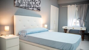 A bedroom with a bed, bedside tables, a desk, and a chair. - Immaculate 12-Bed Apartment in Valencia (Valencia)
