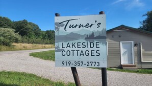 A sign for Turner's Lakeside Cottages with a contact number.