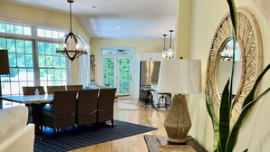 A spacious living area with a dining table, wicker chairs, a sofa, a coffee table, and a potted plant. - Close to the beach! A great multi family home with loads of ammenties.  (Bethany Beach)