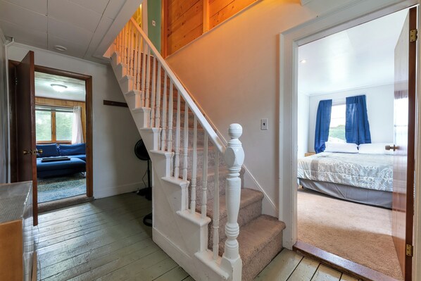 Stairs lead to a cozy bedroom with a bed and window.