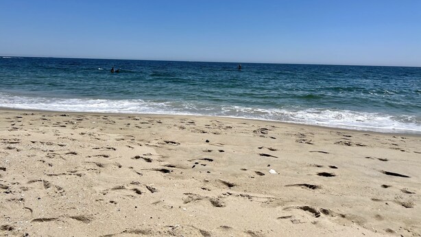 A sandy beach with footprints leading to the water. - BRADLEY BEACH HOUSE with Private Backyard  (Bradley Beach)