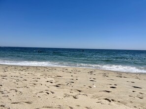 A sandy beach with footprints leading to the water. - BRADLEY BEACH HOUSE with Private Backyard  (Bradley Beach)