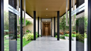 A covered walkway with glass doors, leading to a building entrance. - Grand BS Airport Hotel Suvarnabhumi (Bangkok)