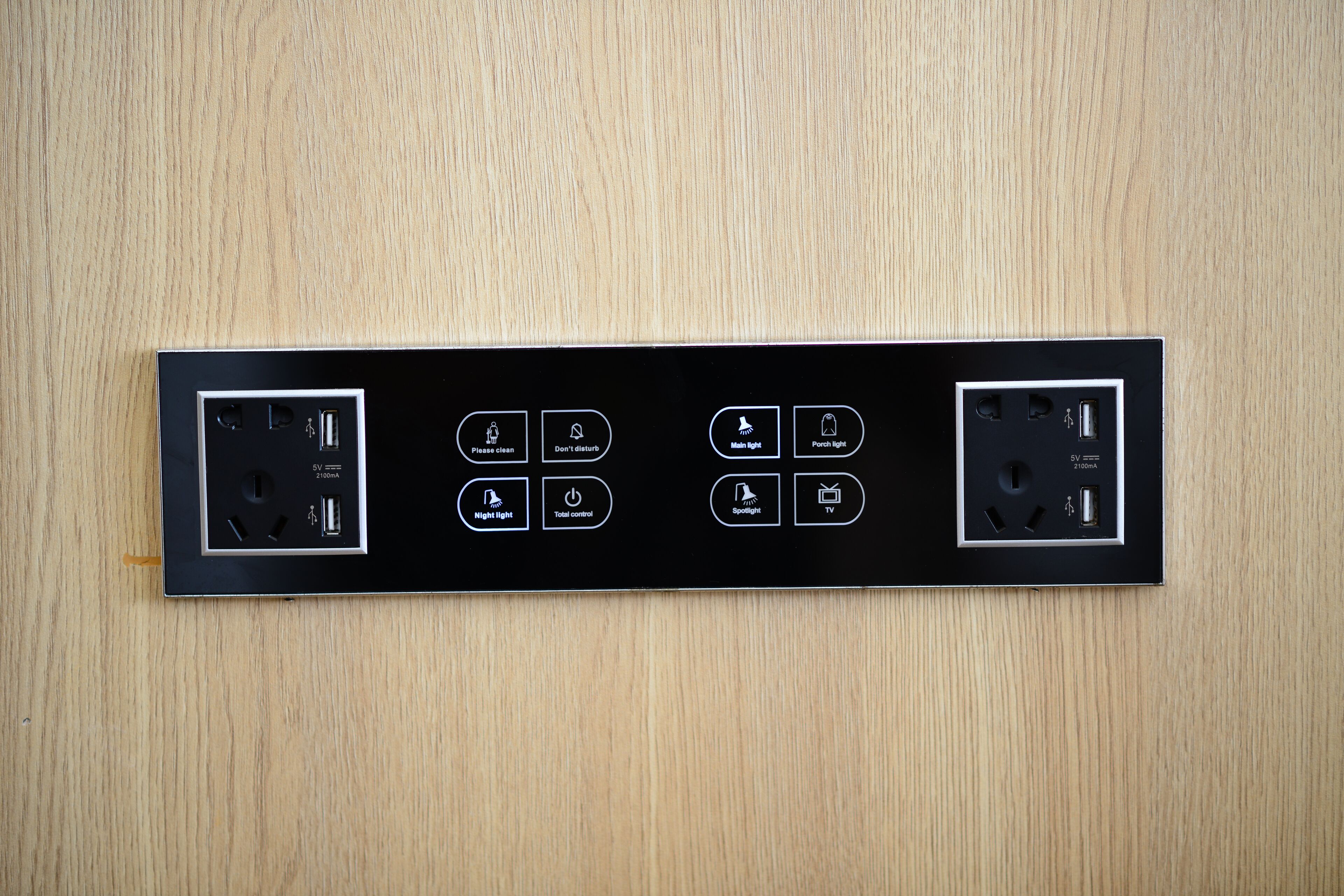 Un tablero eléctrico negro con múltiples enchufes, interruptores, puertos USB y entrada para televisor.