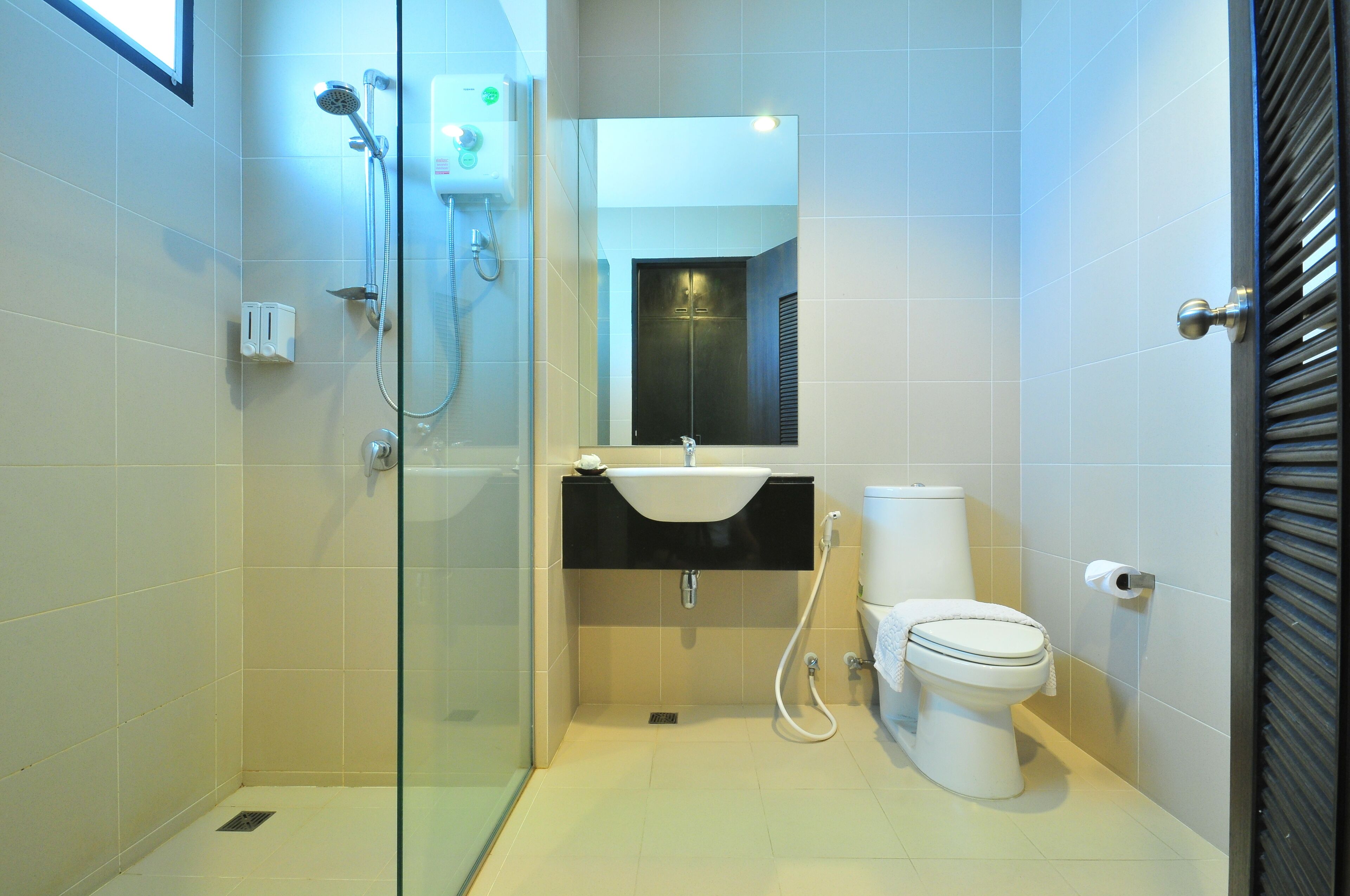 Une salle de bain moderne avec une douche à parois de verre, un lavabo blanc et des toilettes.