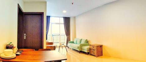 A modern living room with a dining area, a sofa, and a small wooden cabinet.