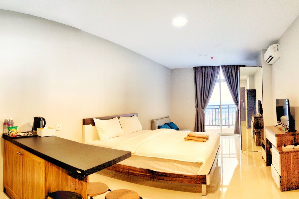Ein Hotelzimmer mit Bett, Schreibtisch, Fernseher und Badezimmer.