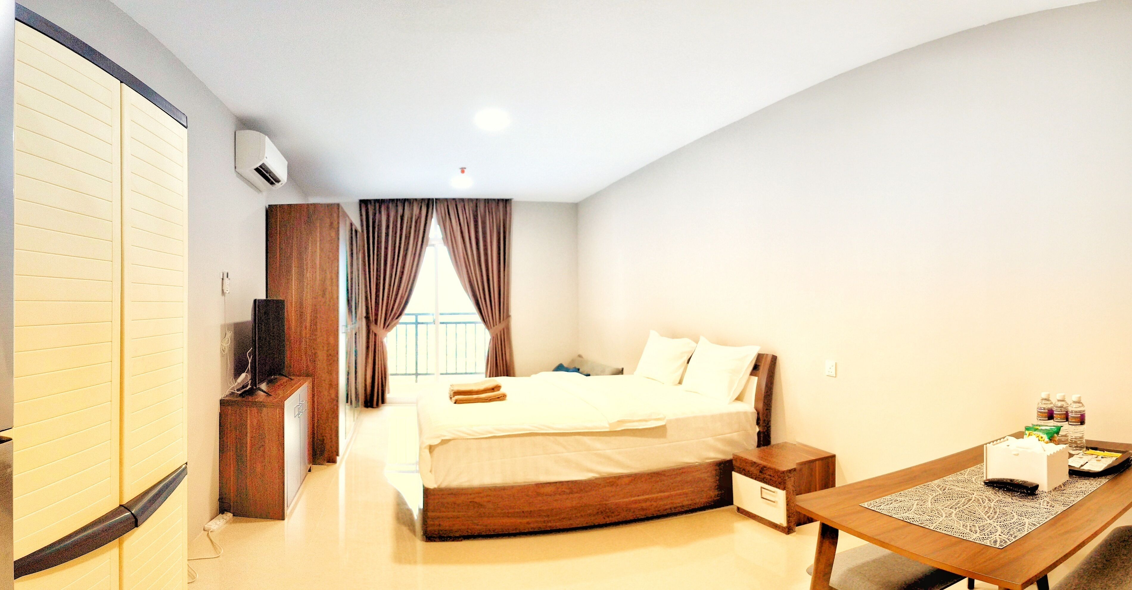 Una habitación de hotel con cama, mesita de noche, televisor y escritorio con silla.