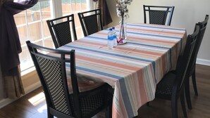 A dining area with a striped tablecloth, black chairs, a vase with flowers, and a framed picture on the wall. - Residential home all hardwood floor, ten minutes from downtown. No pets aloud. (Lexington)