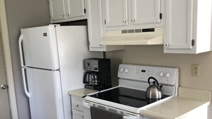 A compact kitchen with white cabinets, a refrigerator, a stove, and a coffee maker. - Residential home all hardwood floor, ten minutes from downtown. No pets aloud. (Lexington)