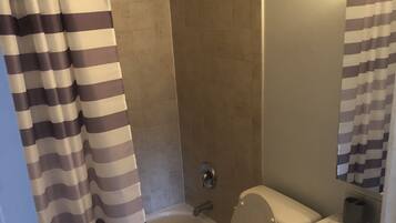 Bathtub, hair dryer, towels, toilet paper